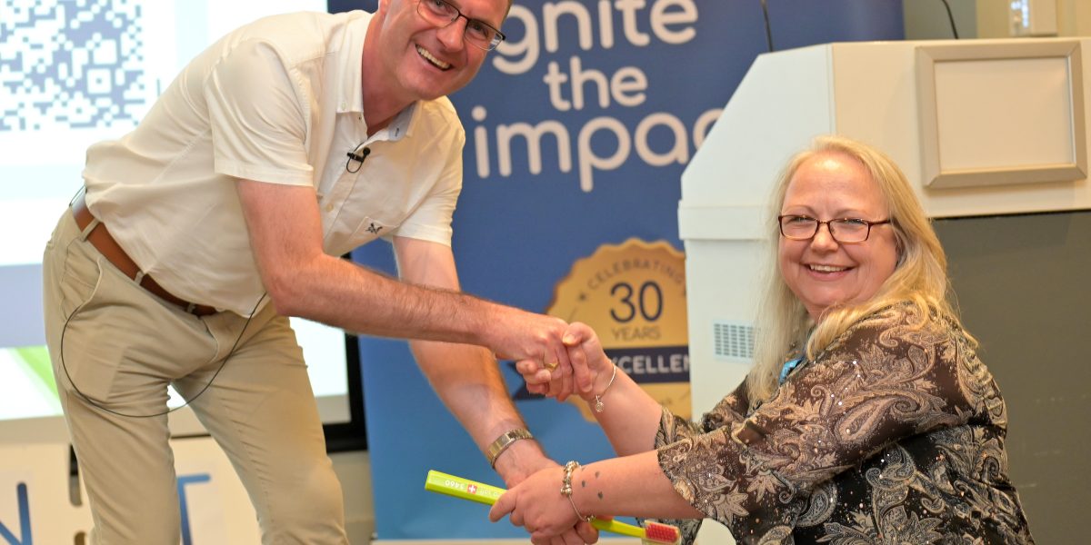 Alan McCartney, Curaden, handing over the 'ceremonial Curaden toothbrush' after delivering an engaging session